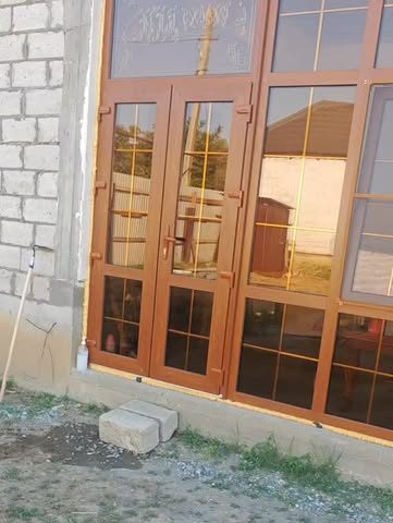 Пластиковые окна и двери цвета дерево на доме